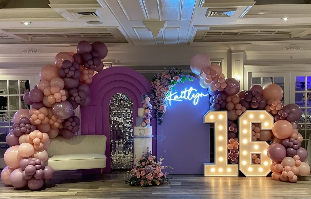 A room decorated with balloons and lights for a birthday party.