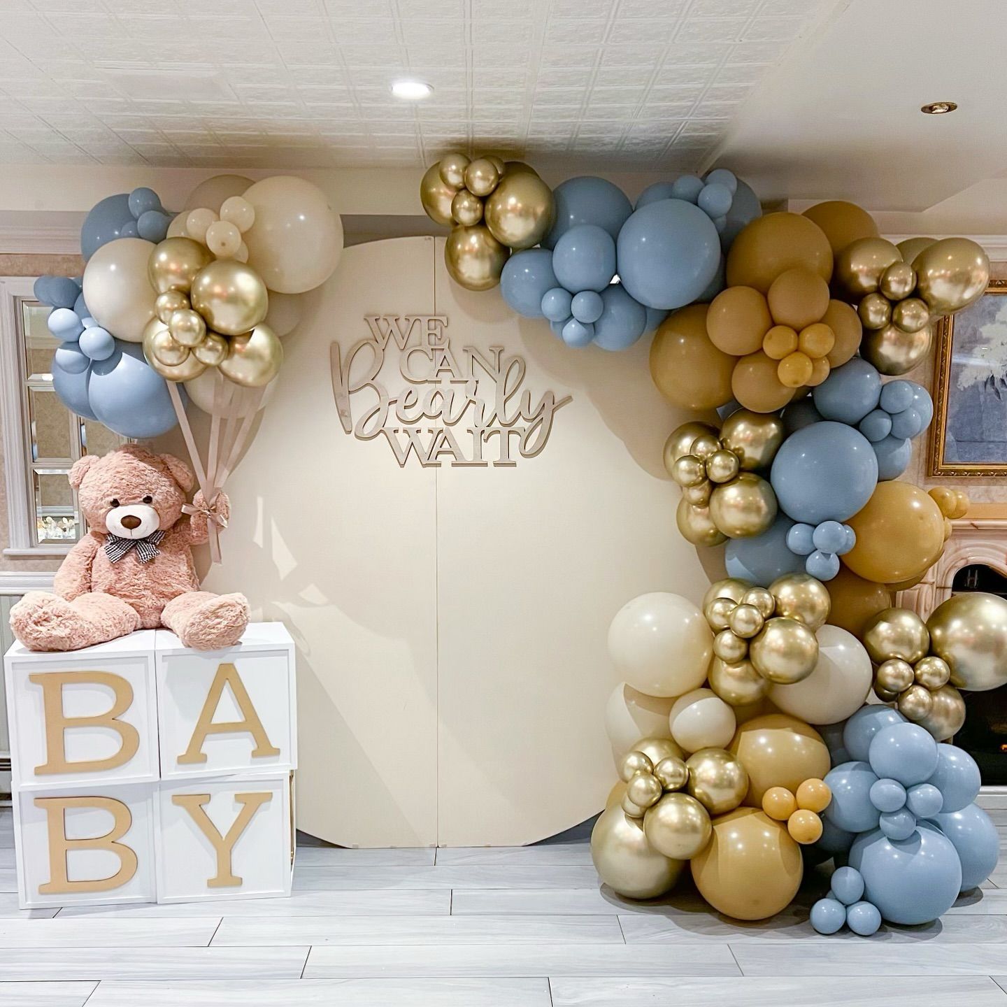 A teddy bear is sitting on a box with the word baby on it