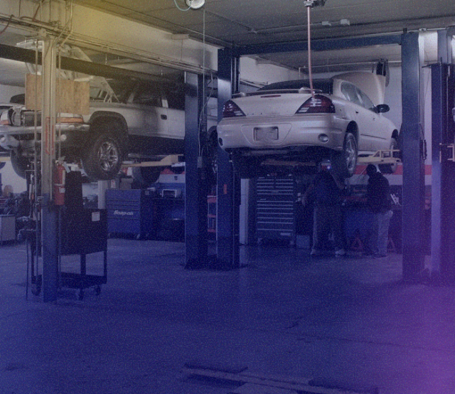A car is sitting on a lift in a garage. | Sunset Tire and Auto Repair