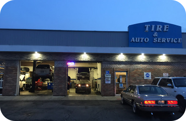 A tire and auto service building with cars parked in front of it | Sunset Tire and Auto Repair