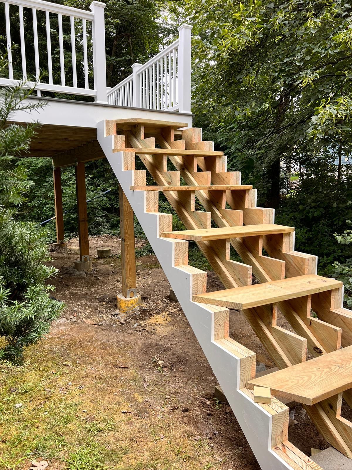 A wooden staircase is being built on top of a wooden deck.