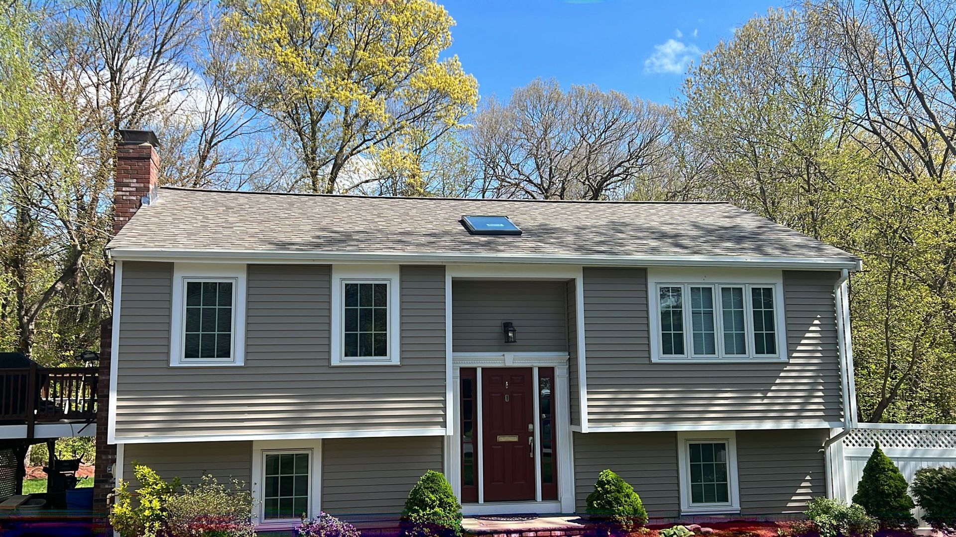 A house with a red door and a skylight on the roof