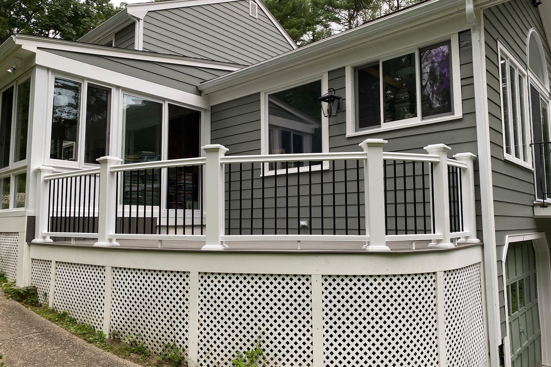A house with a large deck and a white lattice fence.