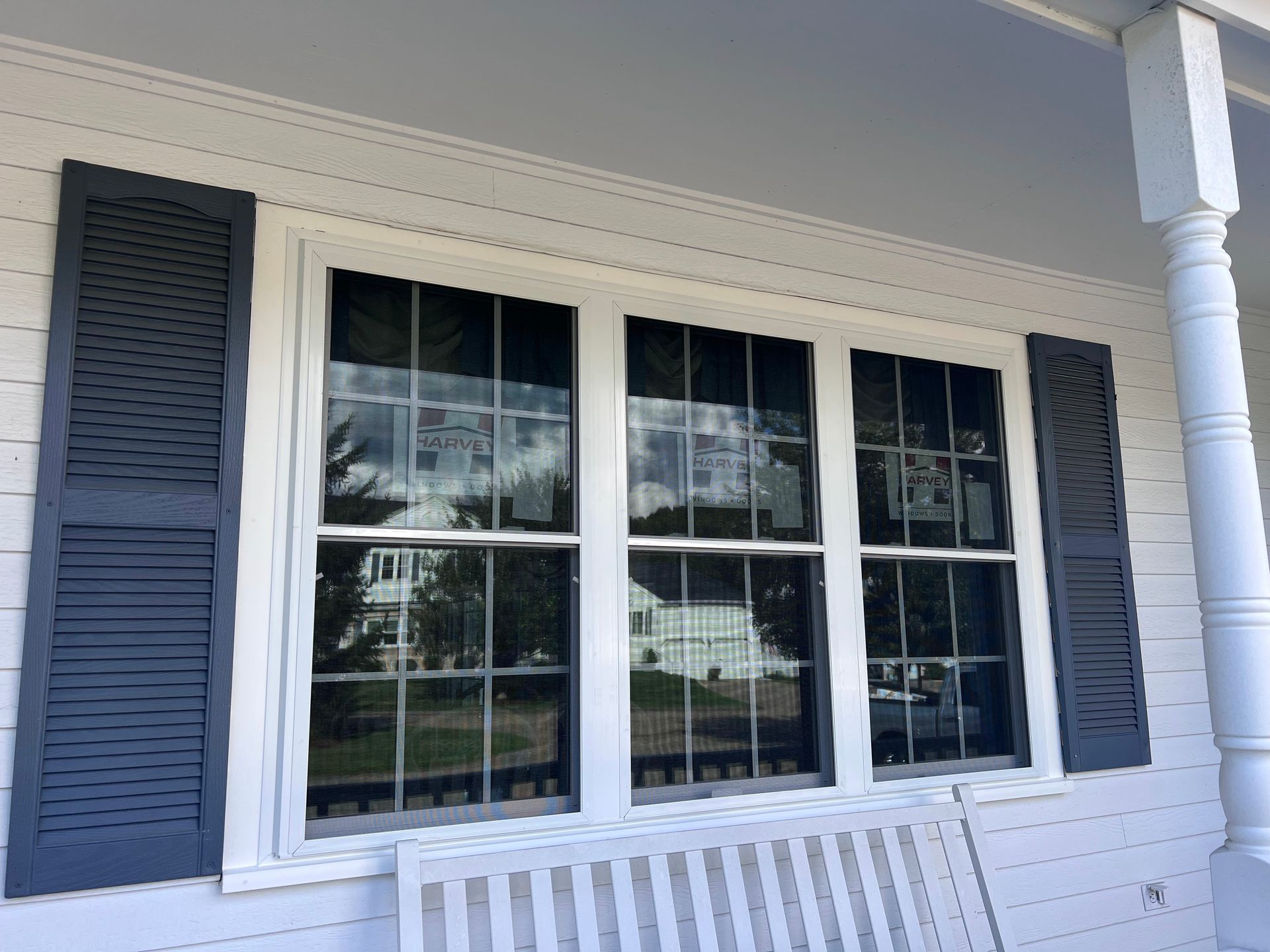 A white house with black shutters and a large window