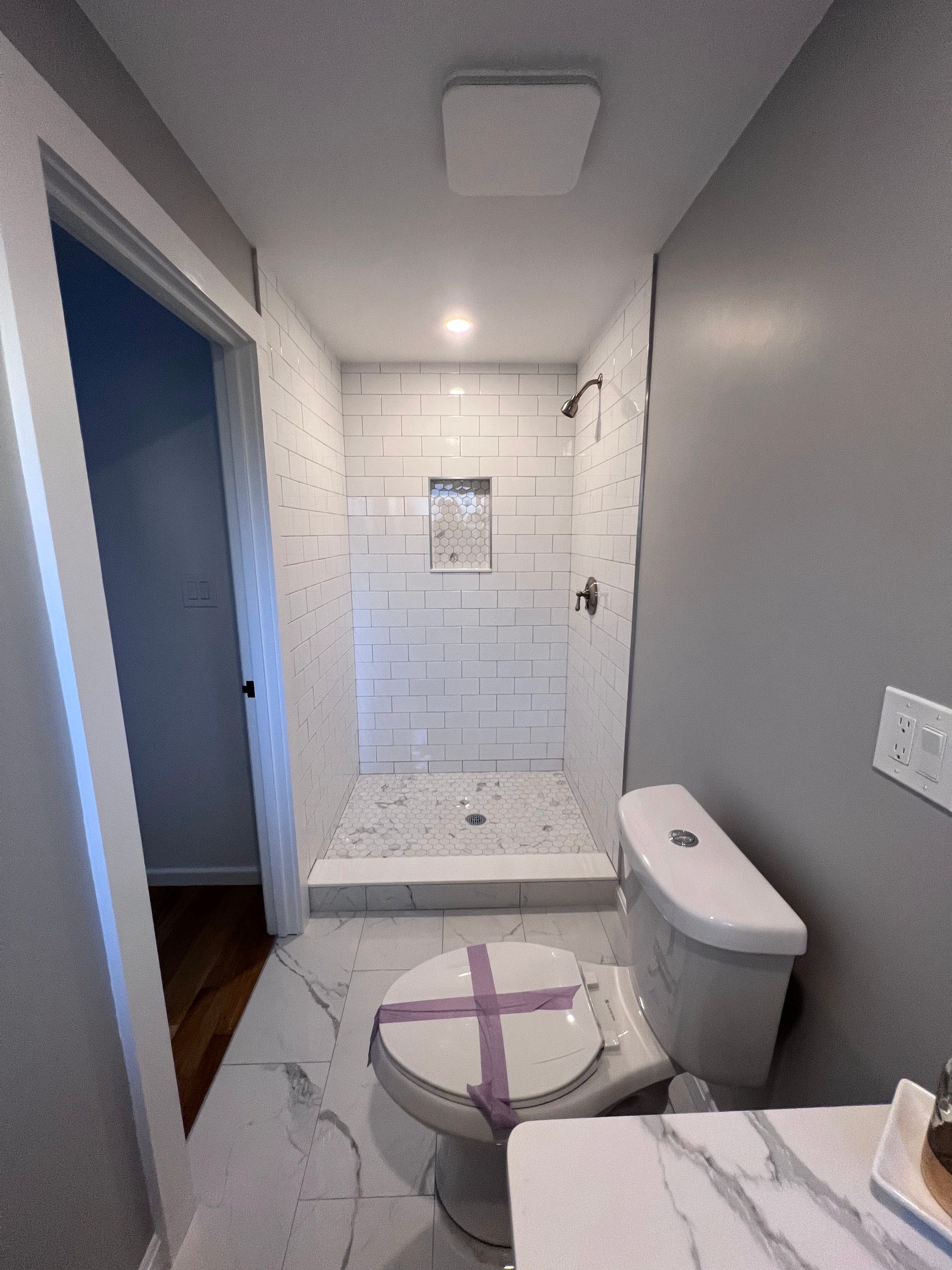 A bathroom with a toilet , shower , and sink
