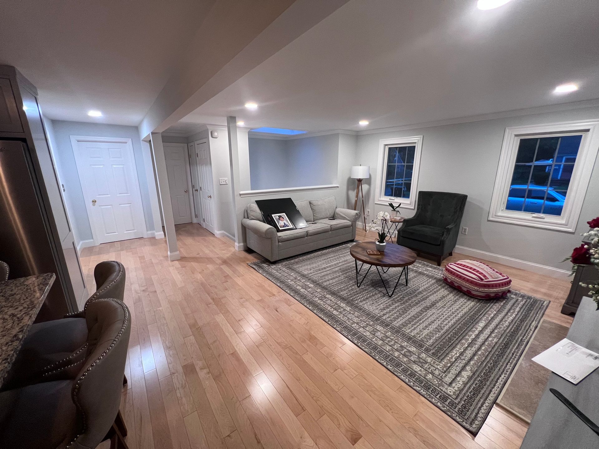 A living room with a couch , chair , coffee table and rug.