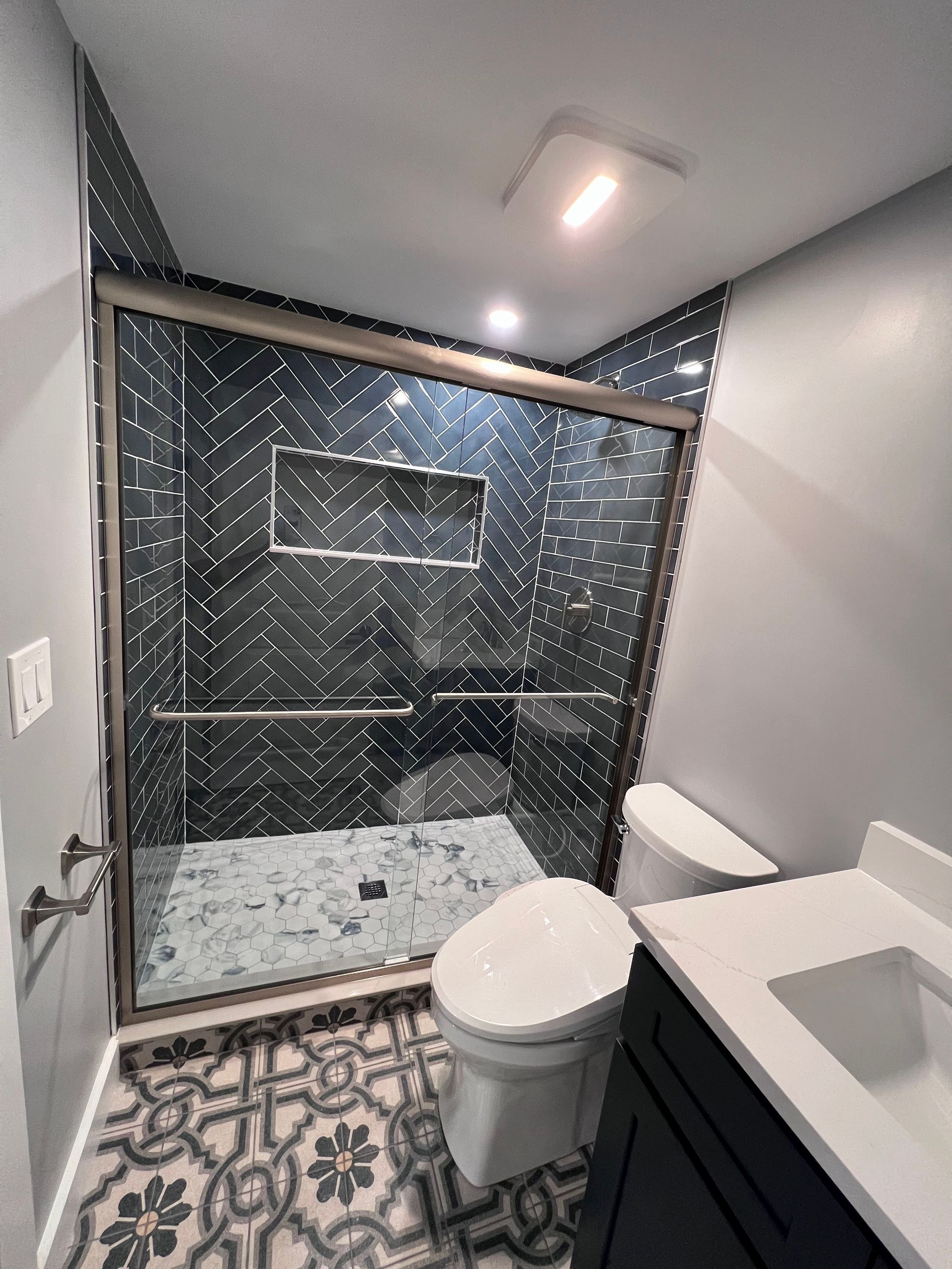 A bathroom with a toilet , sink and shower.