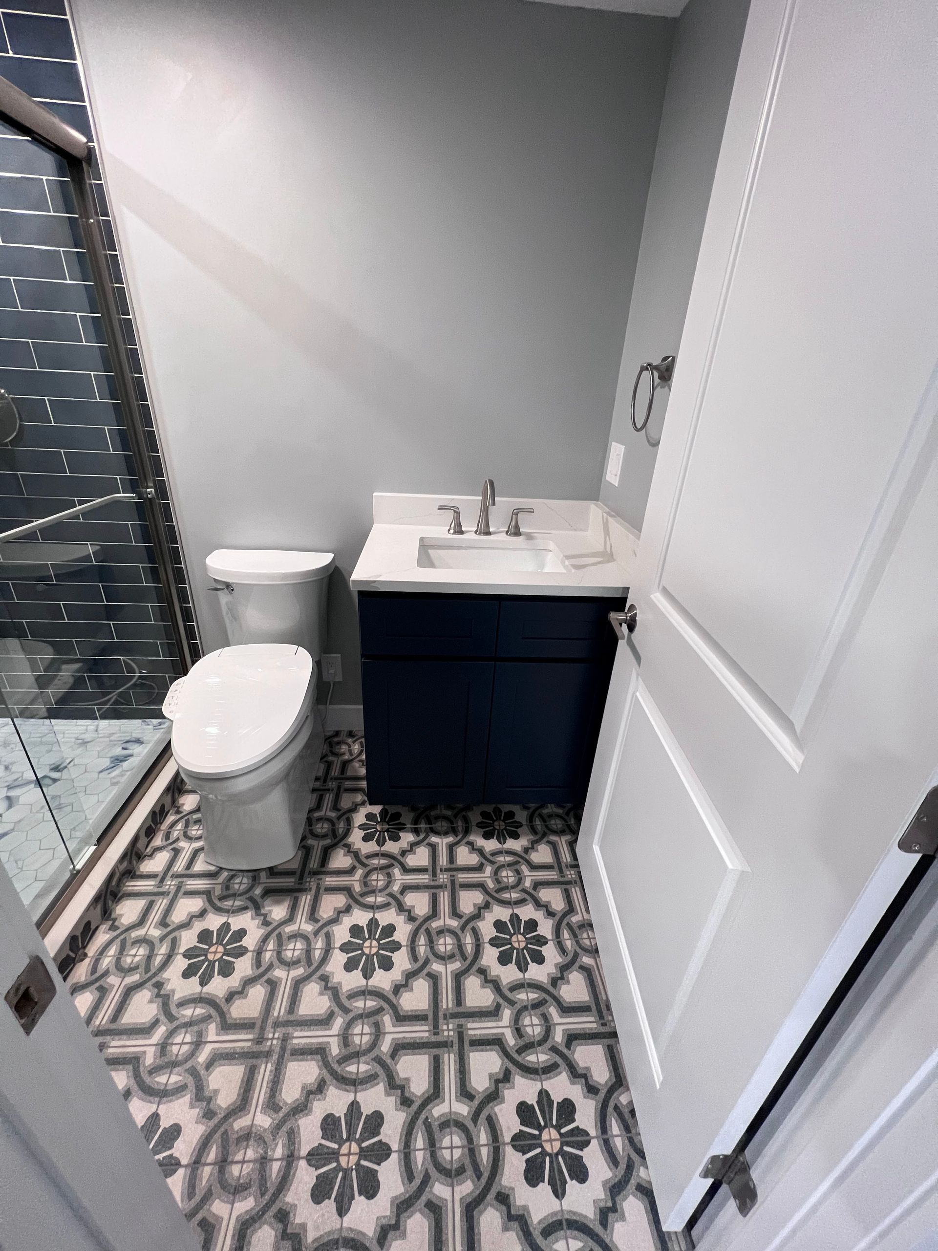 A bathroom with a toilet , sink , and shower.