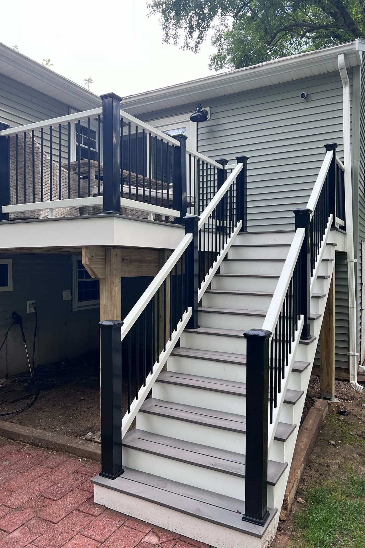 A deck with stairs leading up to it and a black railing.
