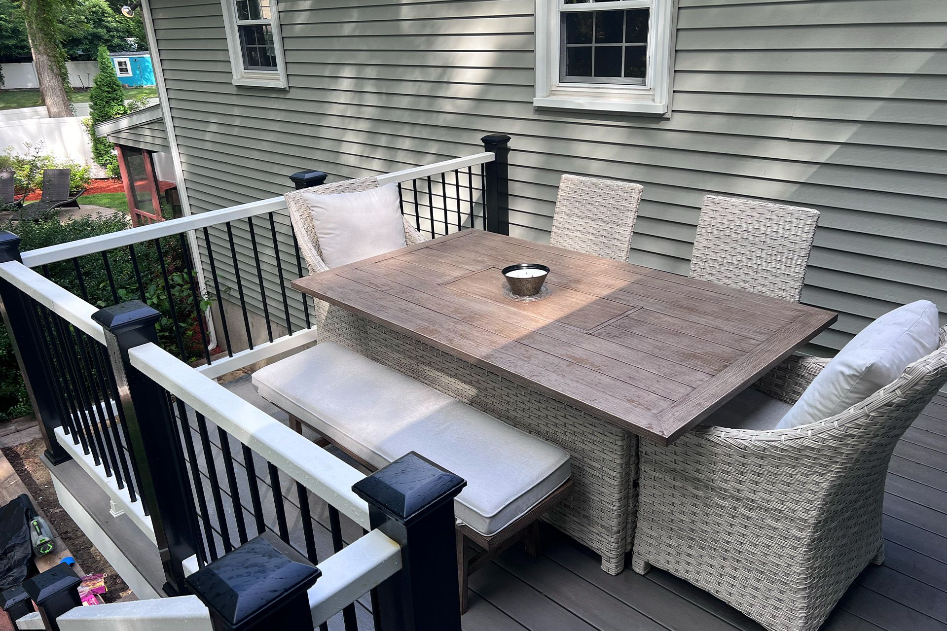 There is a table and chairs on the deck of a house.