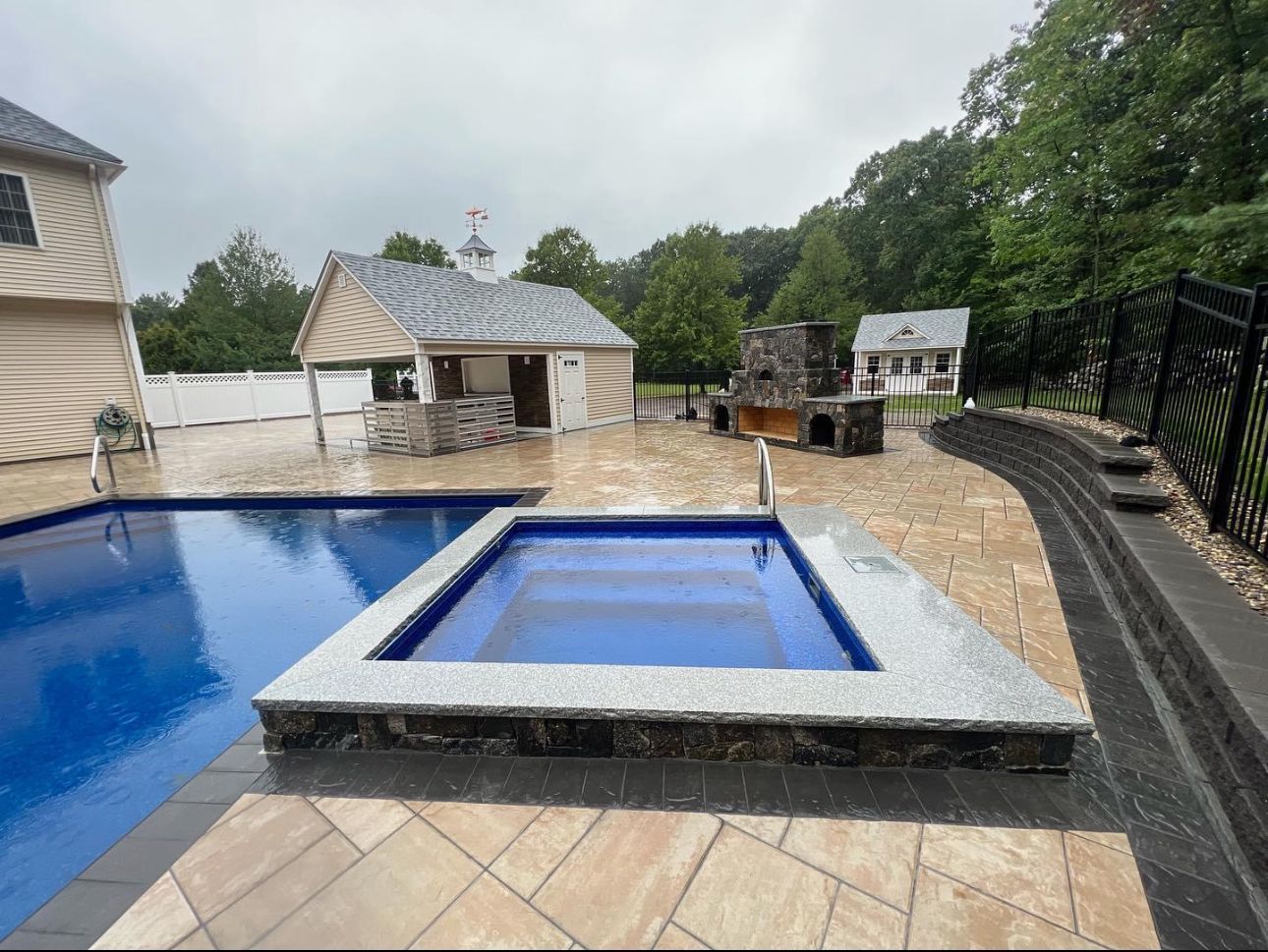 There is a swimming pool and a hot tub in the backyard.