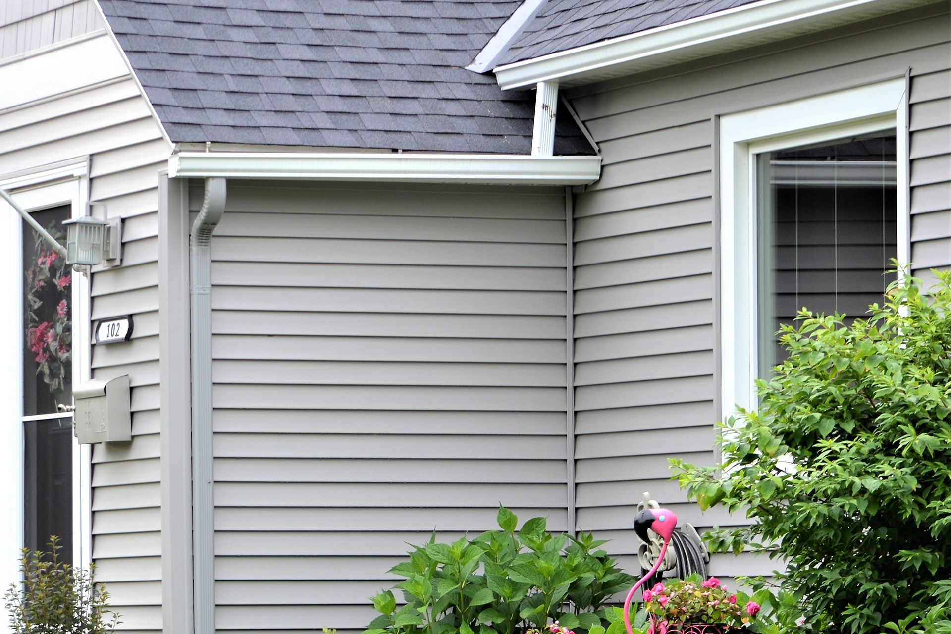 A house with a gray siding and a black roof.