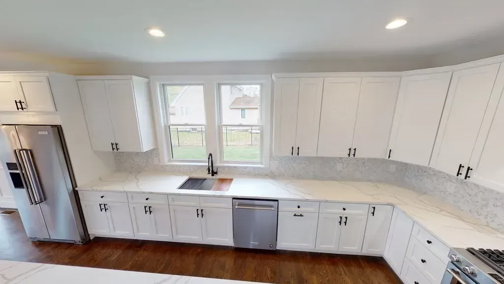 A kitchen with white cabinets and stainless steel appliances