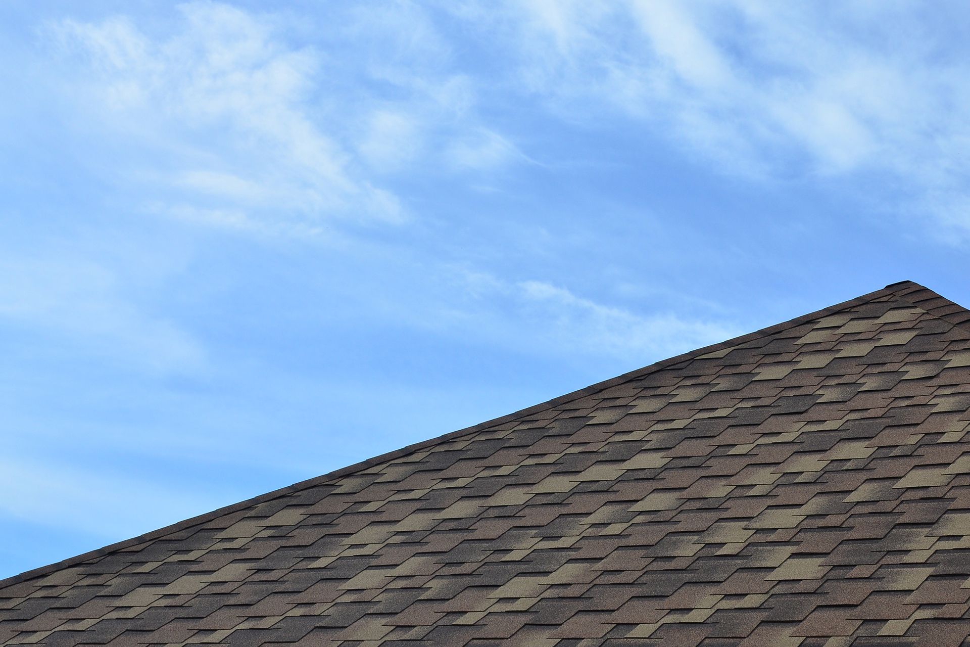 A close up of a roof with a blue sky in the background.
