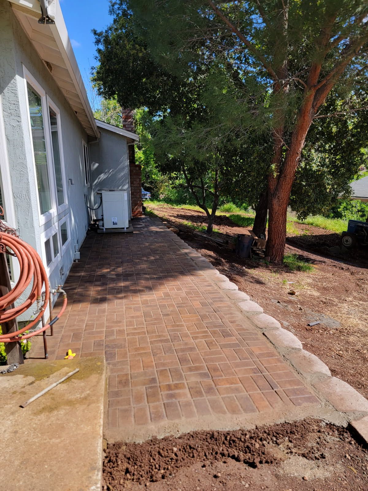 A brick walkway is being built in front of a house
