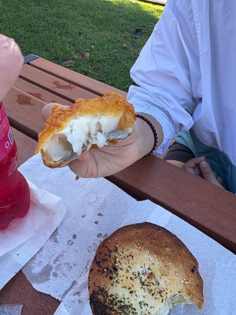 Person Holding a Piece of Battered Fish — Aussie Fish & Chips Nelson Bay in Nelson Bay, NSW