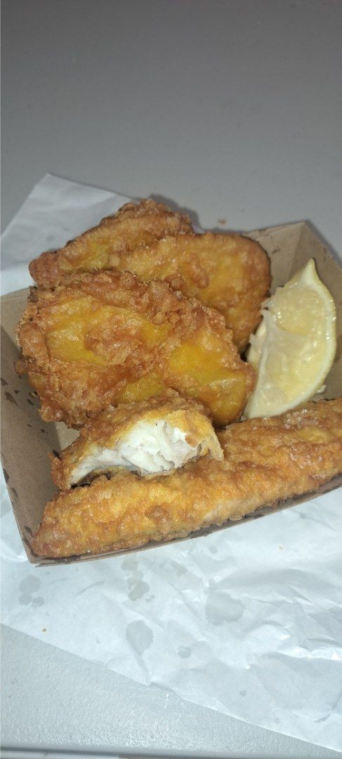 Fried Fish and a Lemon Wedge in a Cardboard Container — Aussie Fish & Chips Nelson Bay in Nelson Bay, NSW