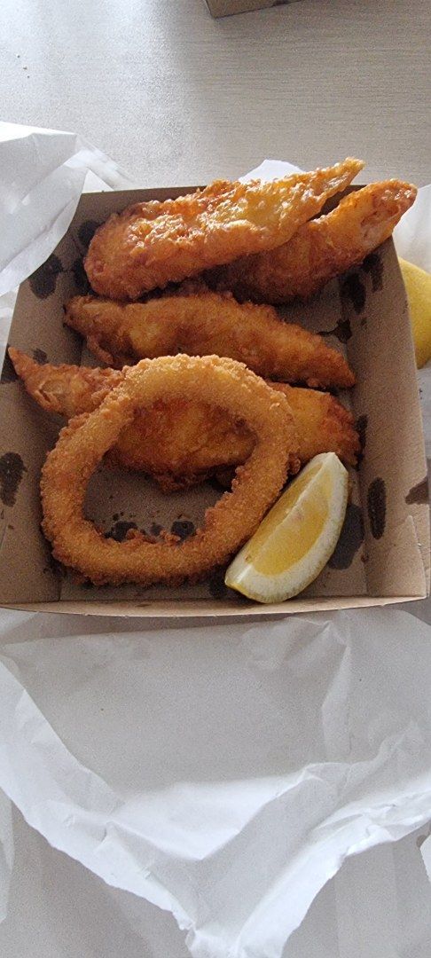 A Box of Fried Food, Including Fish, Onion Rings, and a Lemon Slice — Aussie Fish & Chips Nelson Bay in Nelson Bay, NSW