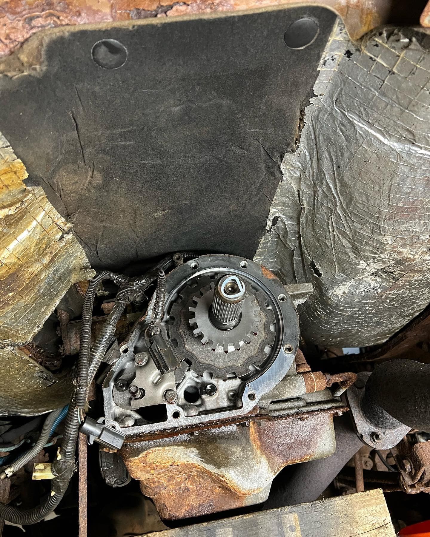 Engine components with a dark flywheel and surrounding insulation.