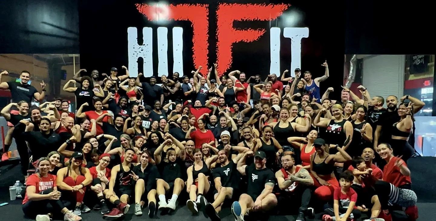 A large group of people are posing for a picture in a gym.