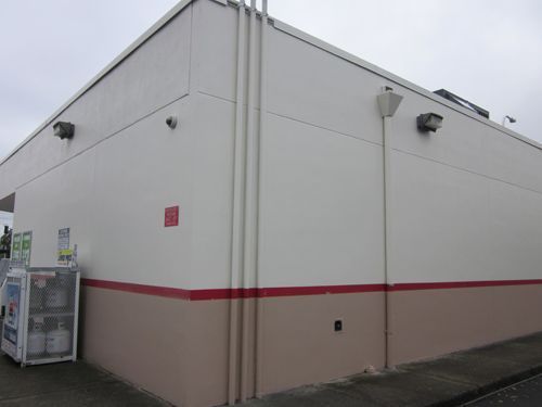 A large white building with a red stripe on the side.