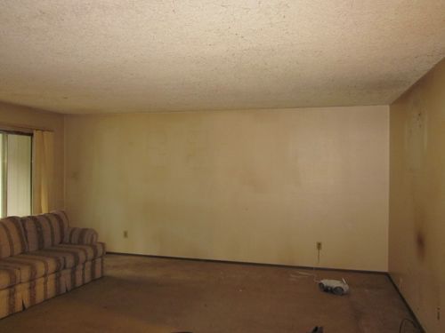 An empty living room with a couch and a window.