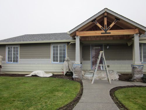 A house that is being painted with a ladder in front of it