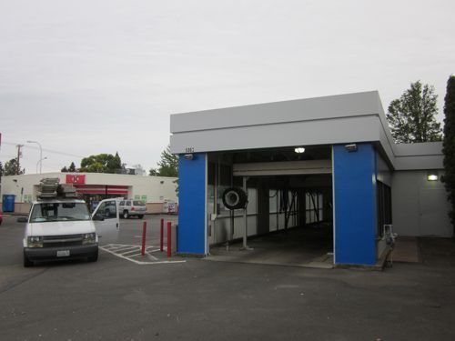 A white van is parked in front of a building