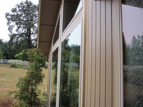 A house with a lot of windows and trees in the background