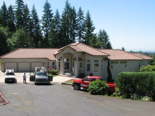 A large white house with a red truck parked in front of it