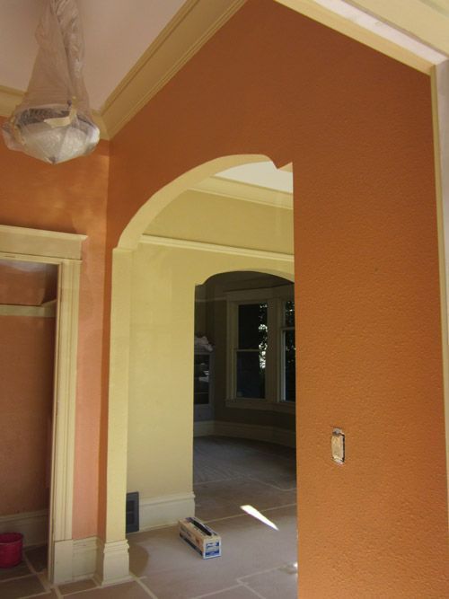 A box on the floor in a room with orange walls