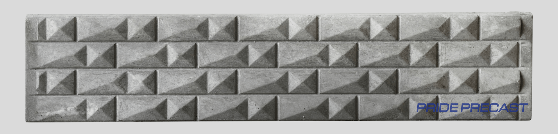 A close up of a concrete wall with pyramids on it