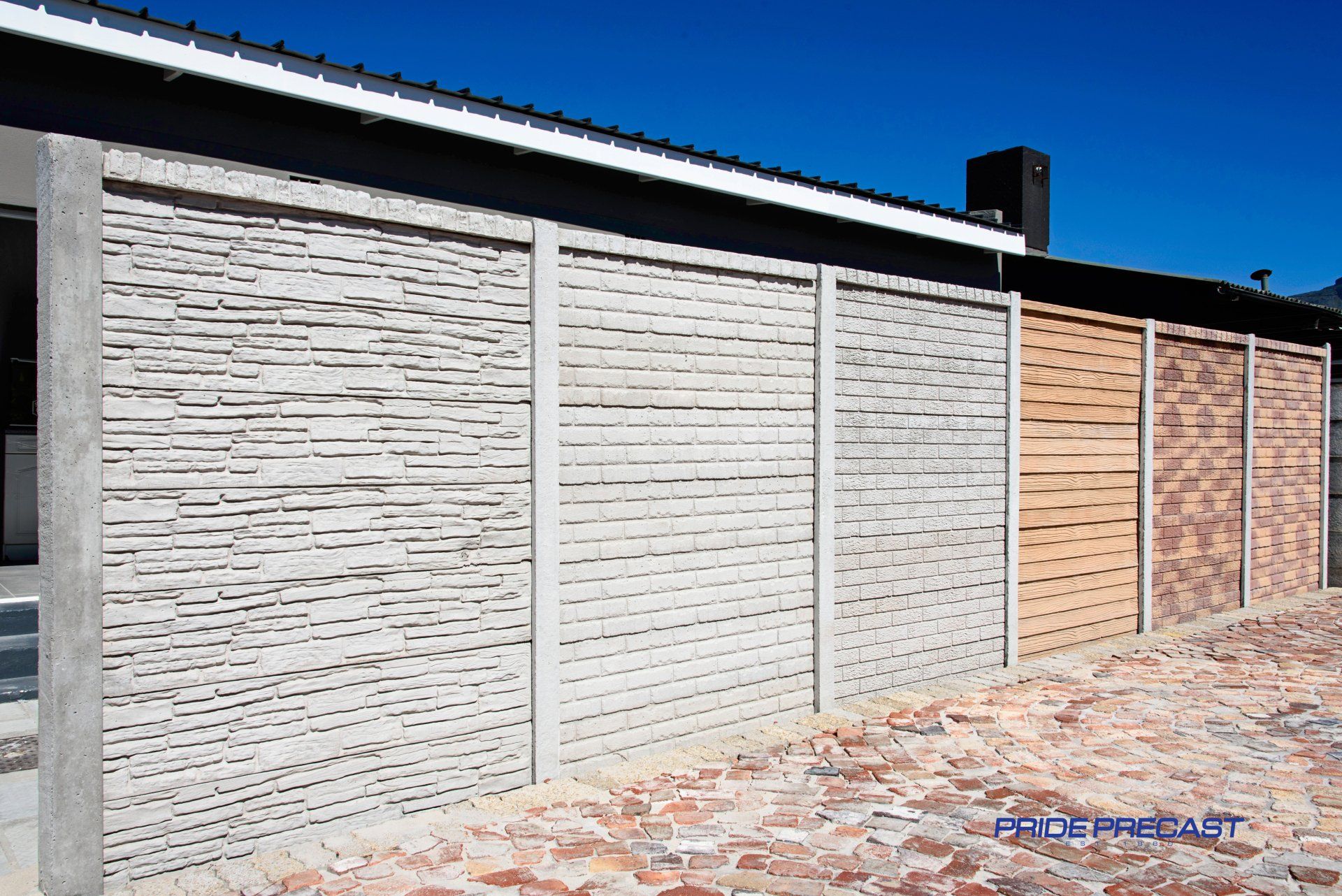 A row of concrete fences are lined up in front of a building