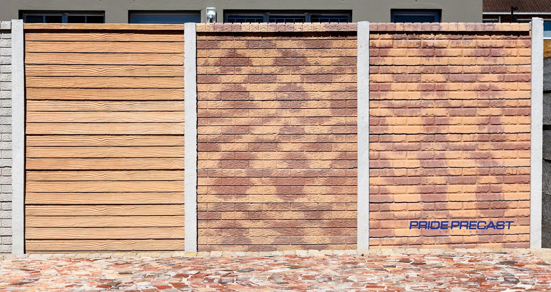 A wooden fence is sitting in front of a brick wall.