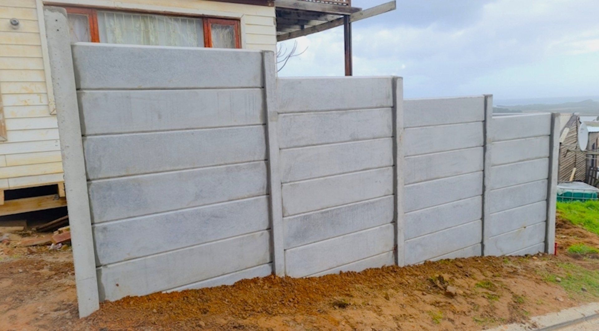 A concrete fence is being built in front of a house.