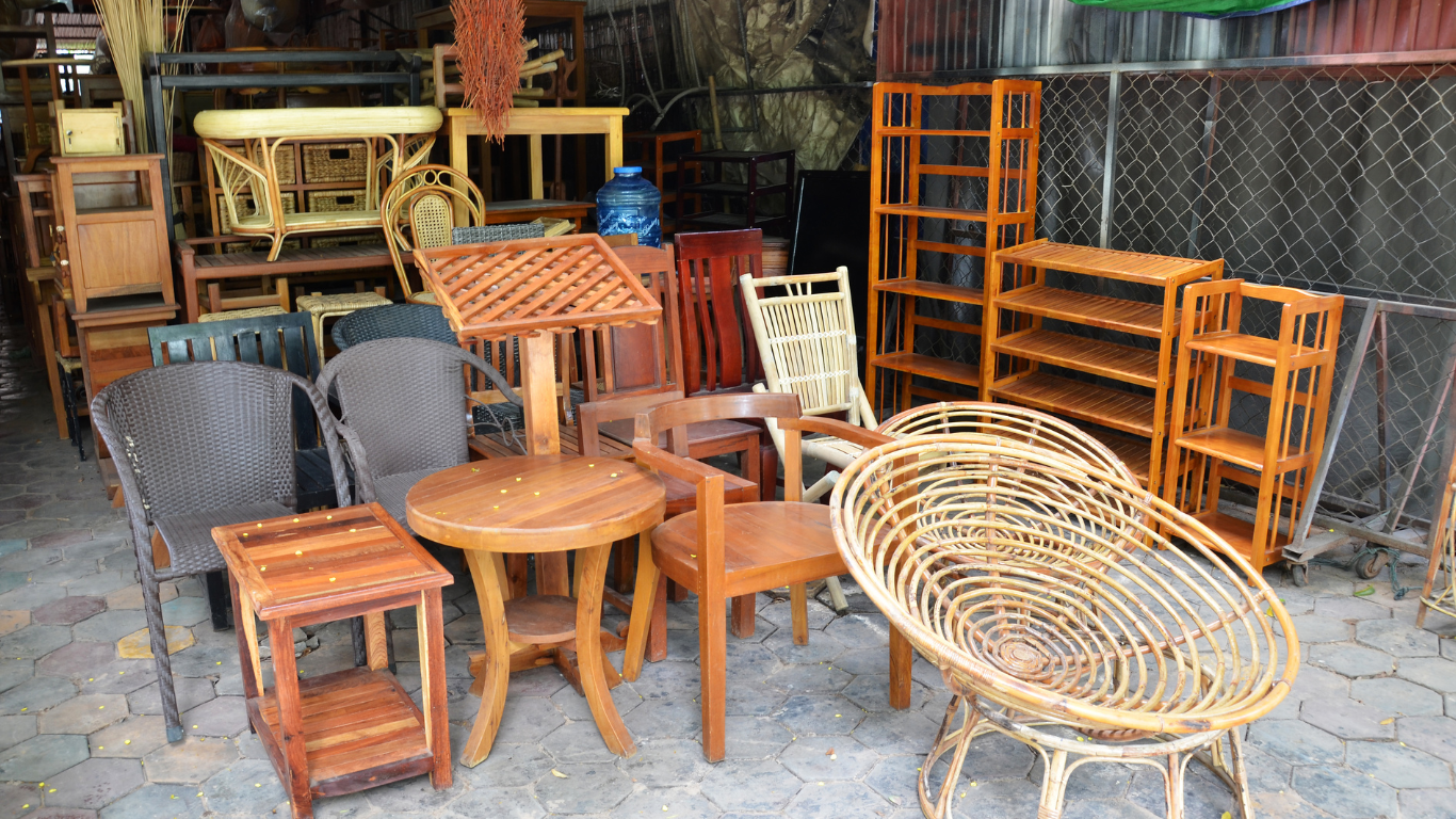 A bunch of wooden furniture is sitting on the ground ready for a clean out.