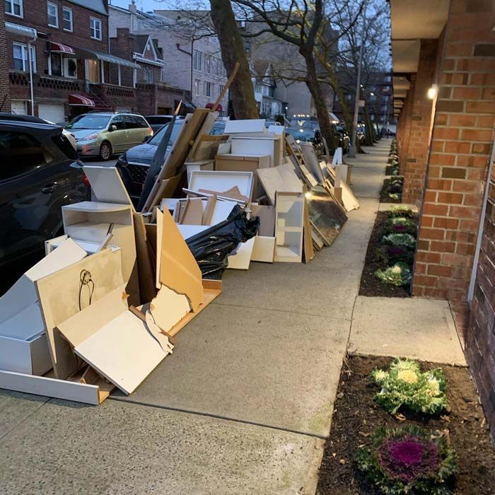 A sidewalk with a lot of junk on it - debris cleanup