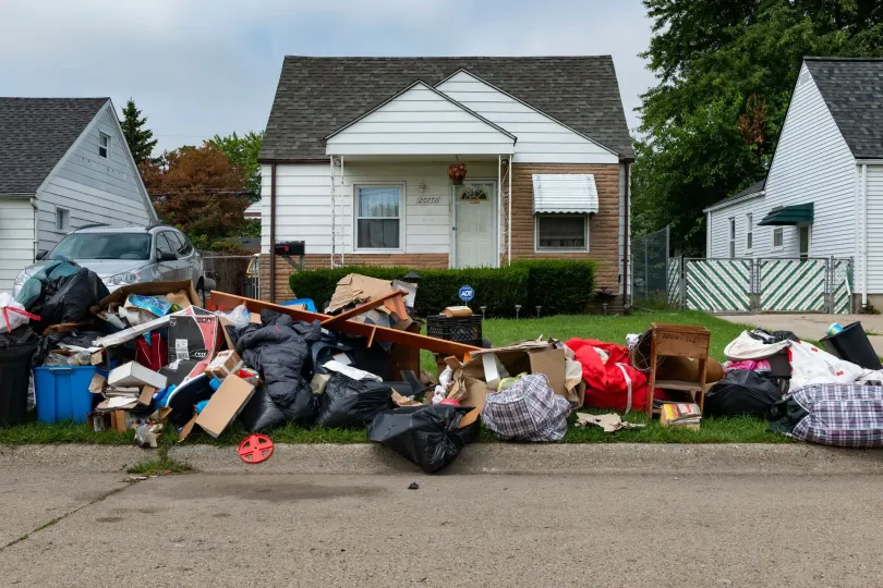 A pile of trash is sitting on the side of the road in front of a house. - dons demolition