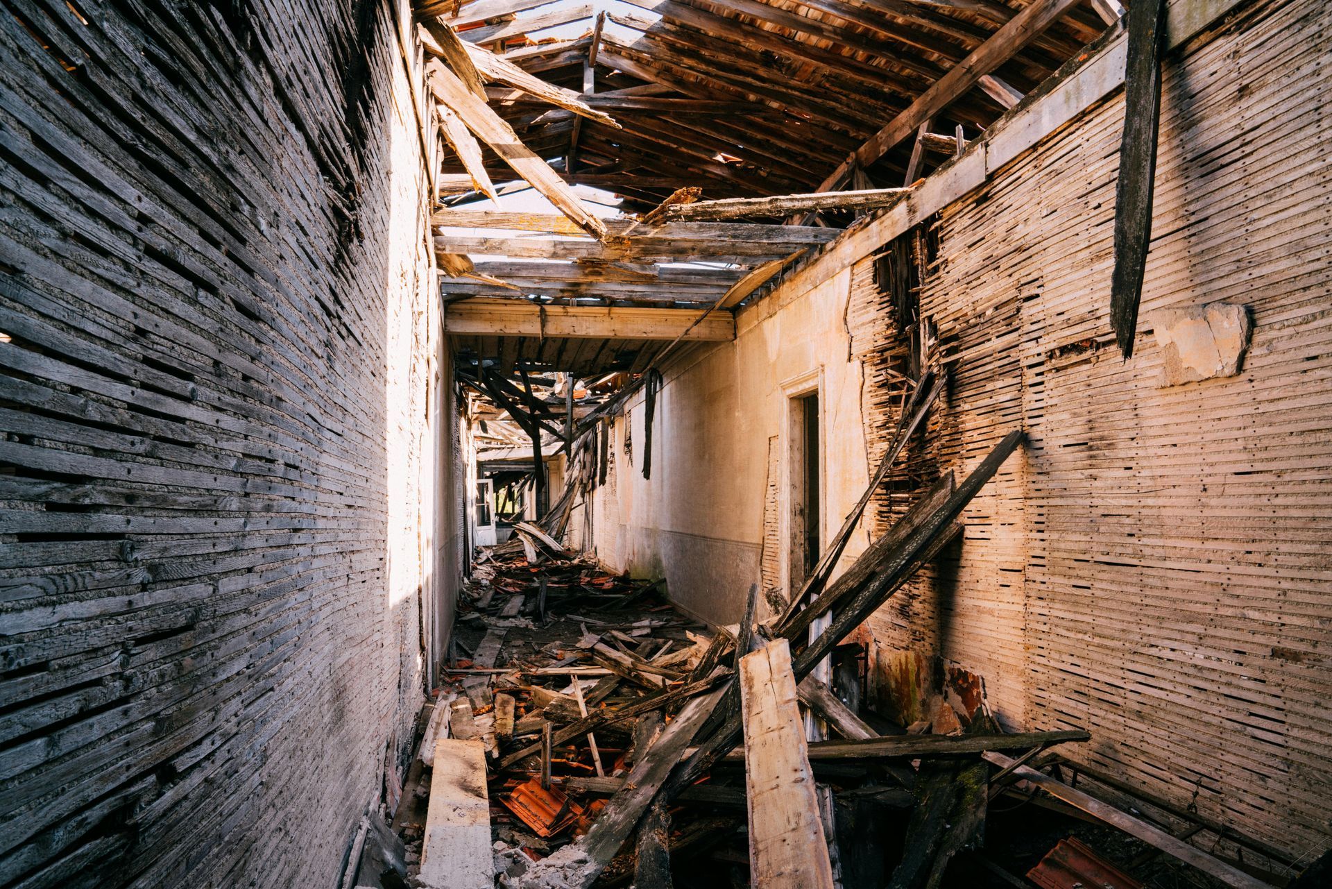 A long hallway in an abandoned building with a roof that is missing. - interior demolition massapequa ny