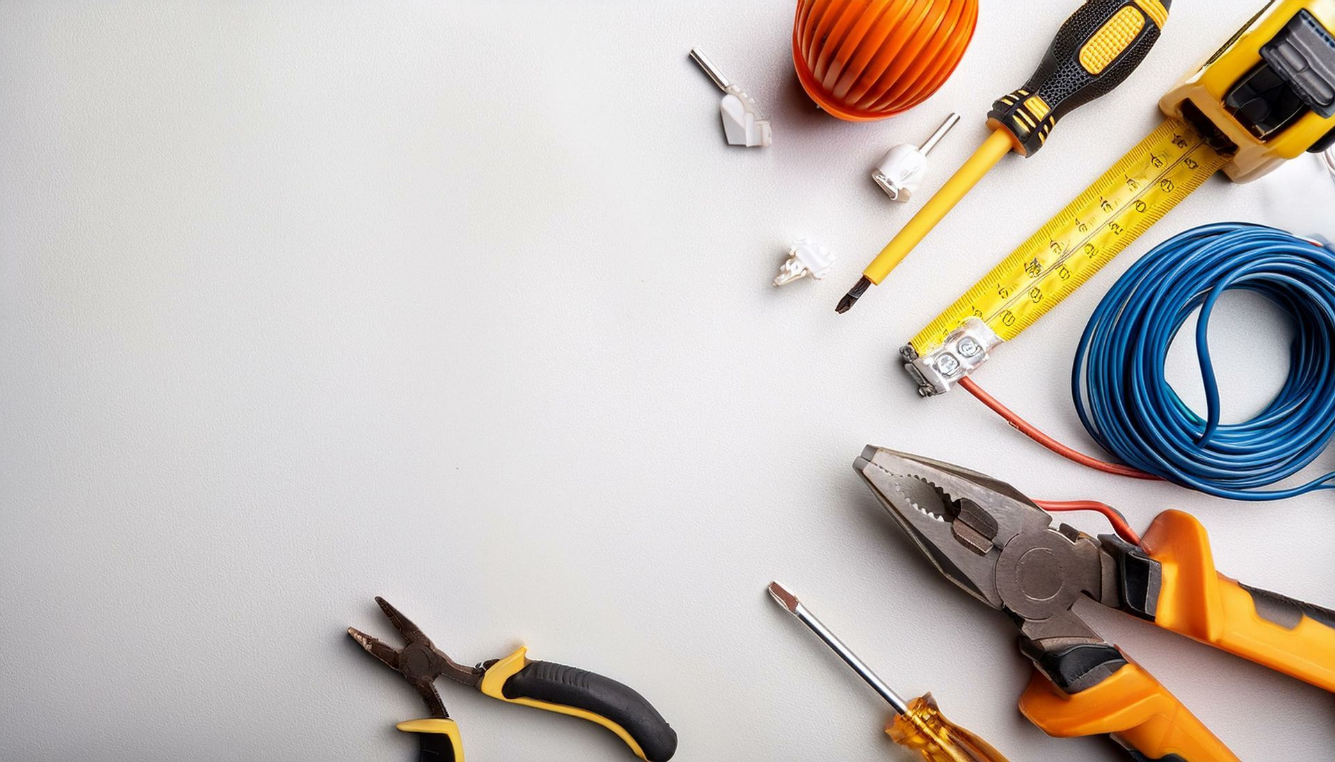 Un tas d'outils sont posés sur une surface blanche.