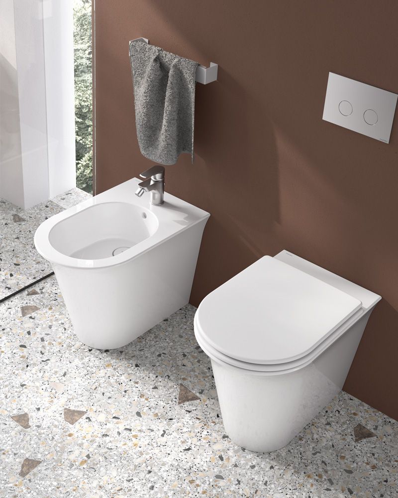 Een badkamer met een bidet en een toilet.