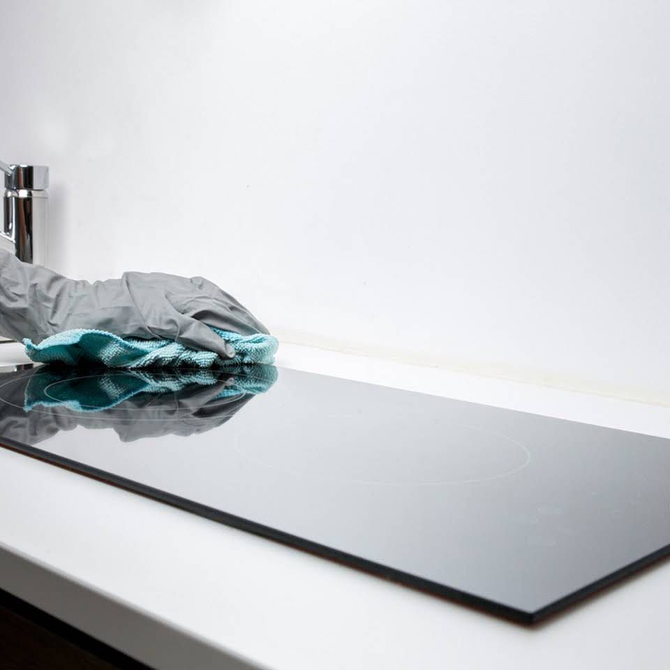 A Black Stove Top with A Cloth on Top of It — North Coast Commercial Cleaners In Caloundra, QLD