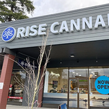 Rise Cannabis store exterior with sign and open door.