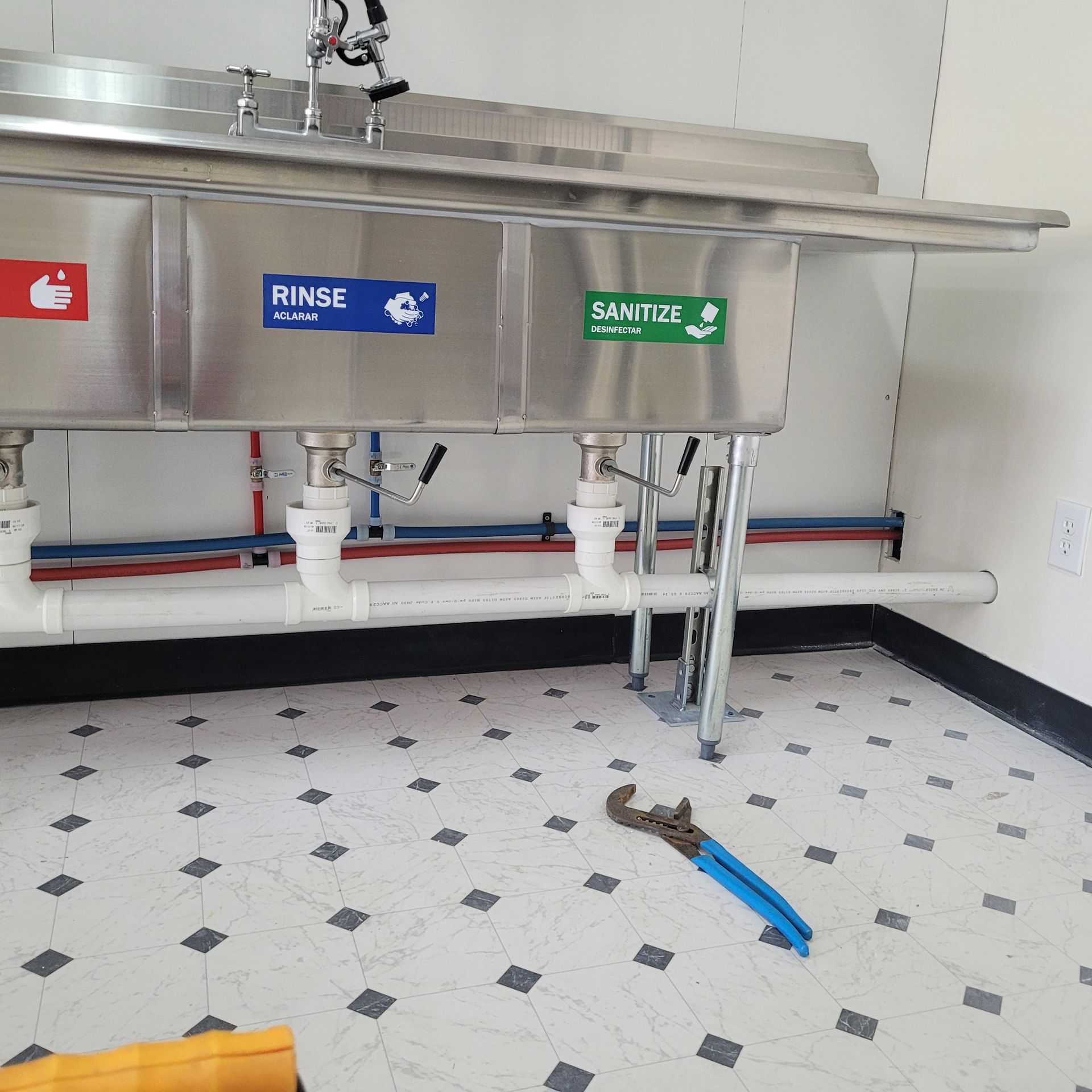 A stainless steel sink with the words rinse and sanitize on it