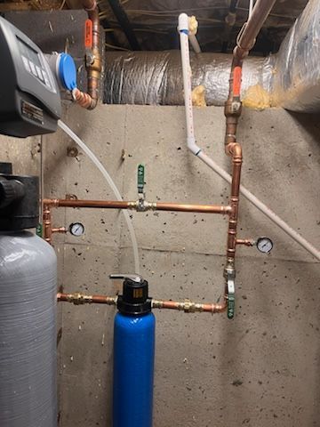 A room with a lot of pipes and a blue bottle.