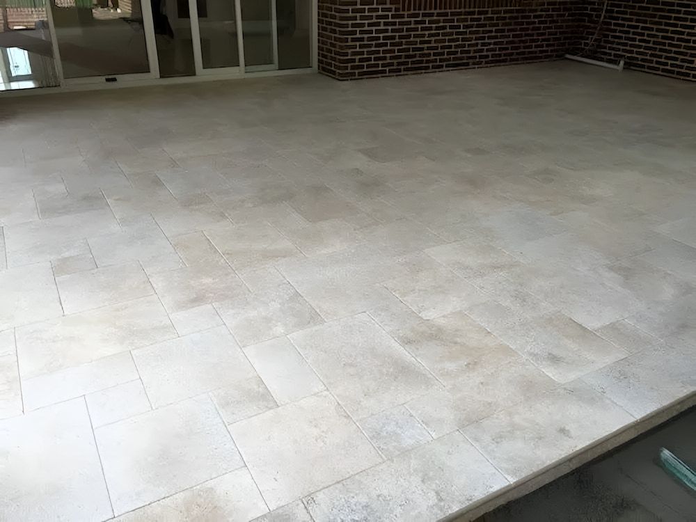 A White Tiled Floor With A Brick Wall — Corrimal Ceramic Tiles Pty Ltd in Corrimal, NSW