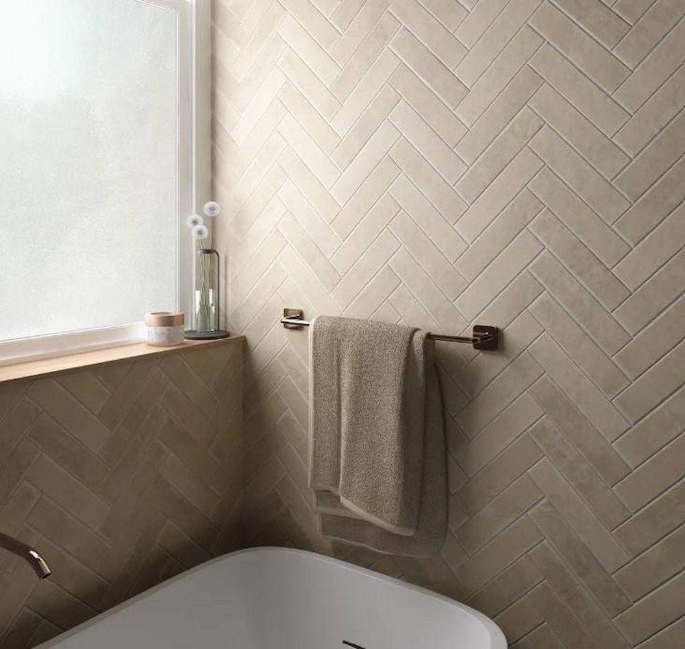 A Bathroom With A Bathtub And A Window With A Herringbone Tile Wall — Corrimal Ceramic Tiles Pty Ltd in Corrimal, NSW