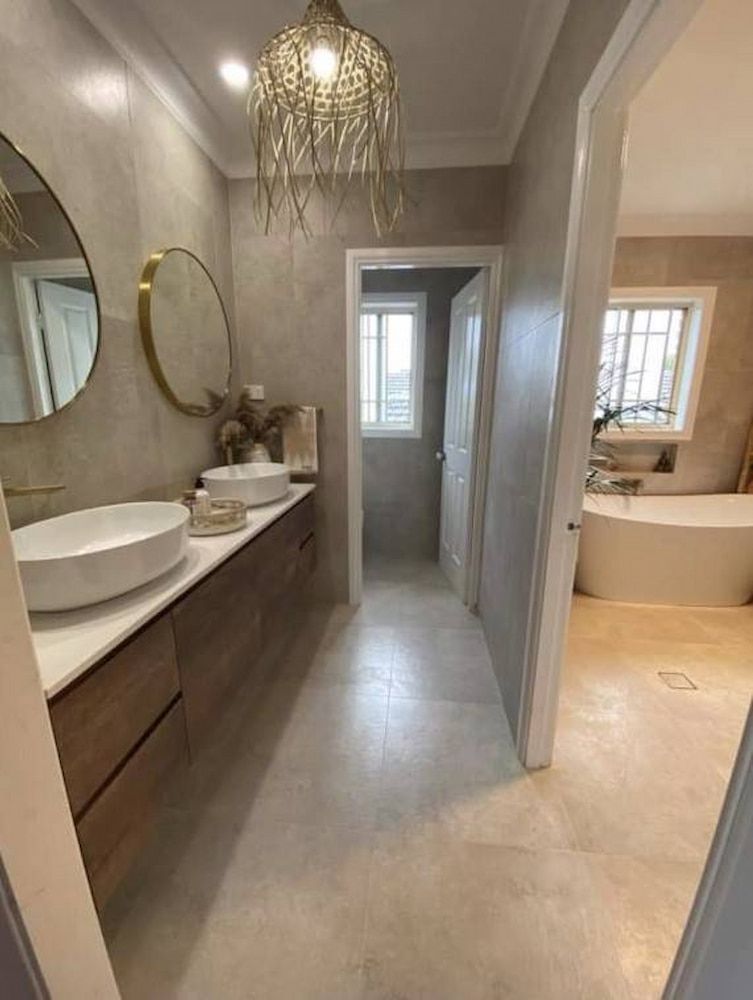 A Bathroom With Two Sinks, A Mirror And A Bathtub — Corrimal Ceramic Tiles Pty Ltd in Corrimal, NSW