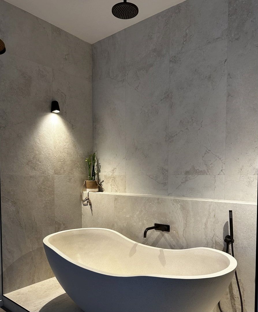 A Bathroom With A Bathtub And A Shower Head — Corrimal Ceramic Tiles Pty Ltd in Corrimal, NSW
