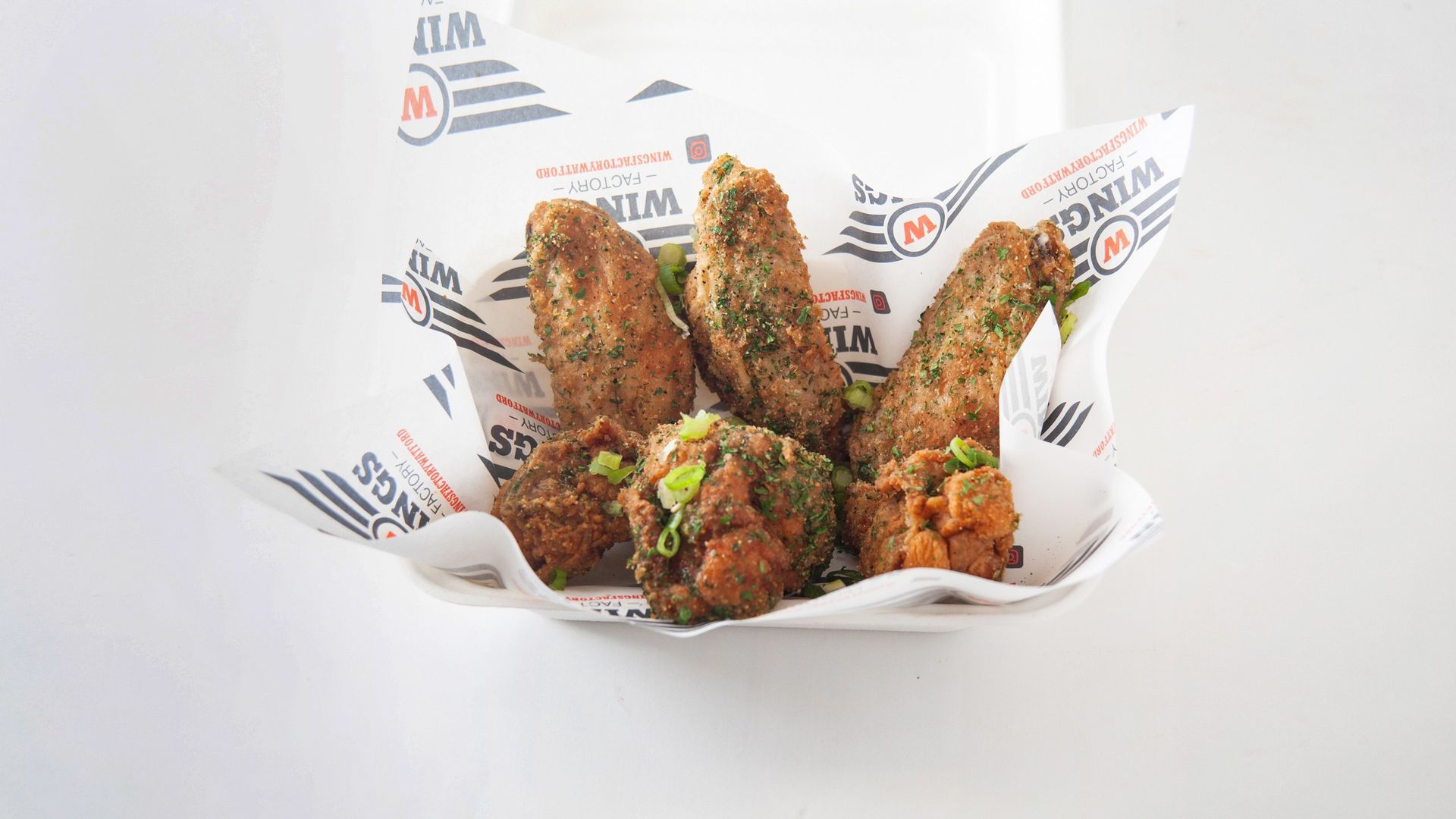 A bowl of fried food is sitting on a piece of paper.